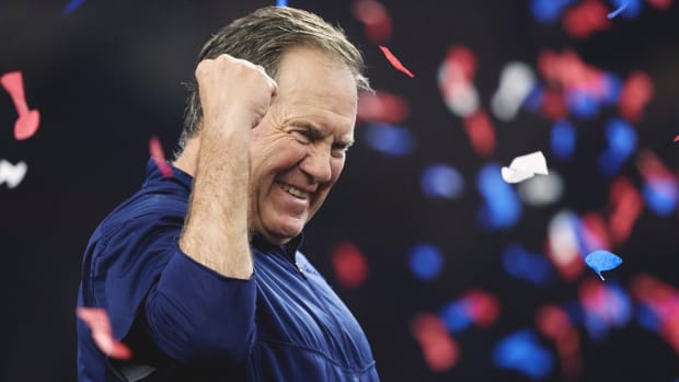 Bill Belichick pumps his fist as confetti falls behind him